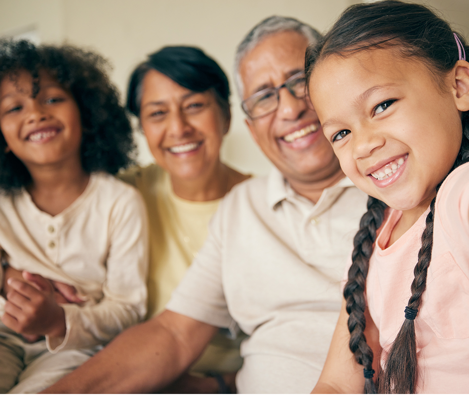 A grandfather and grandmother with 2 grandchildren smiling